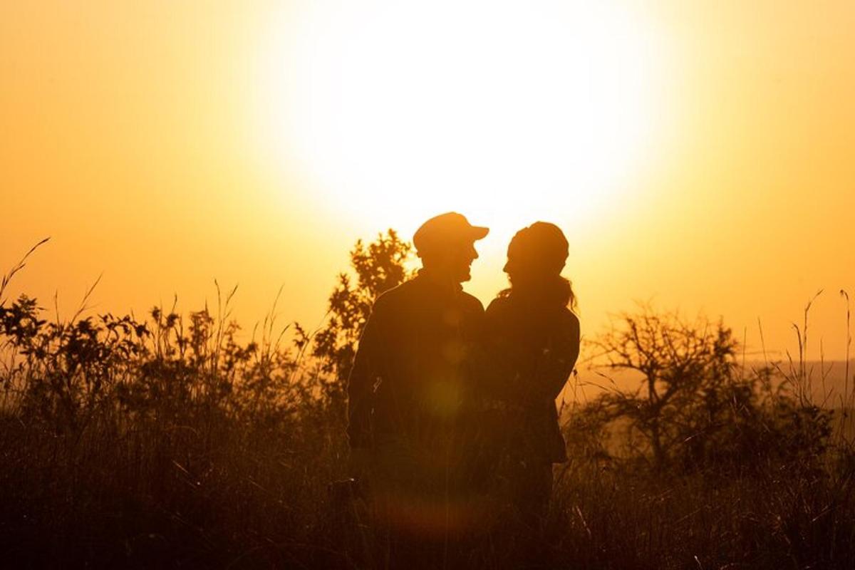 un uomo e una donna in piedi davanti al tramonto