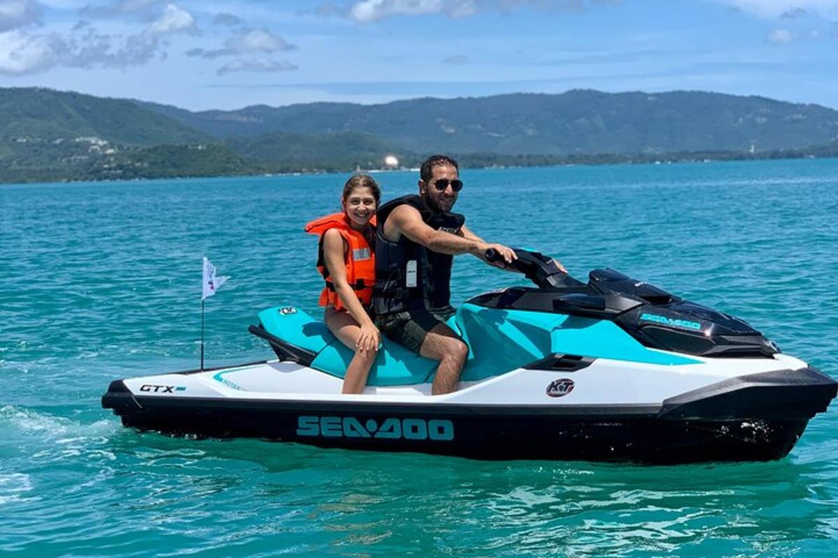 un uomo e una donna seduti su una moto d'acqua in acqua