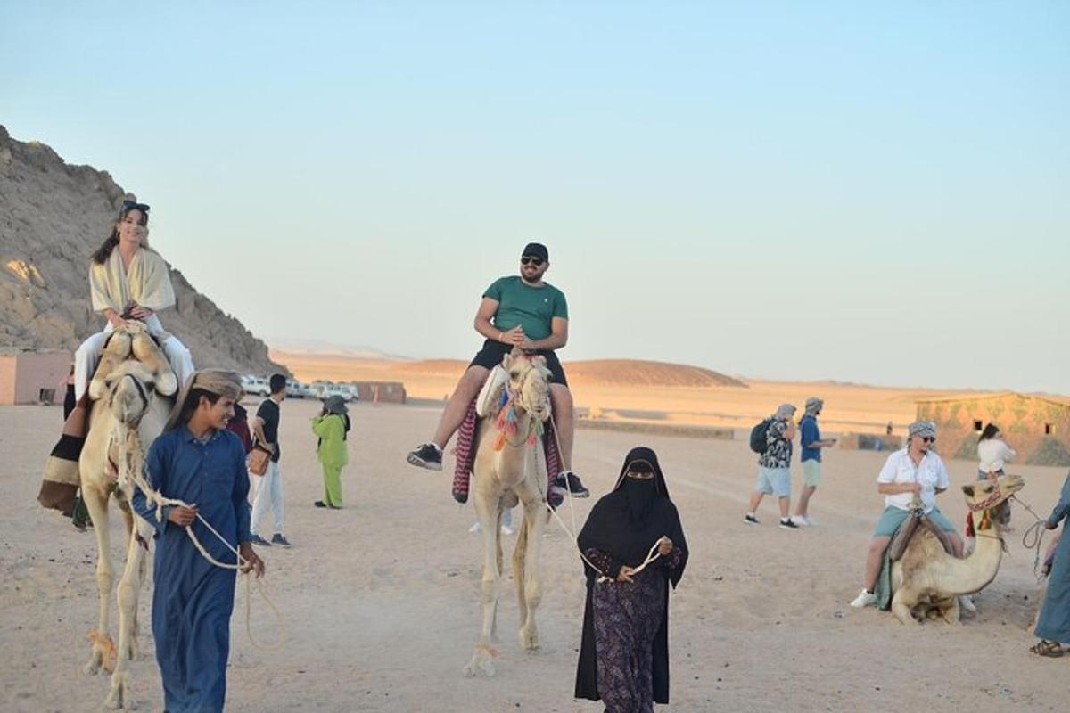 Un grupo de personas montando camellos en el desierto.
