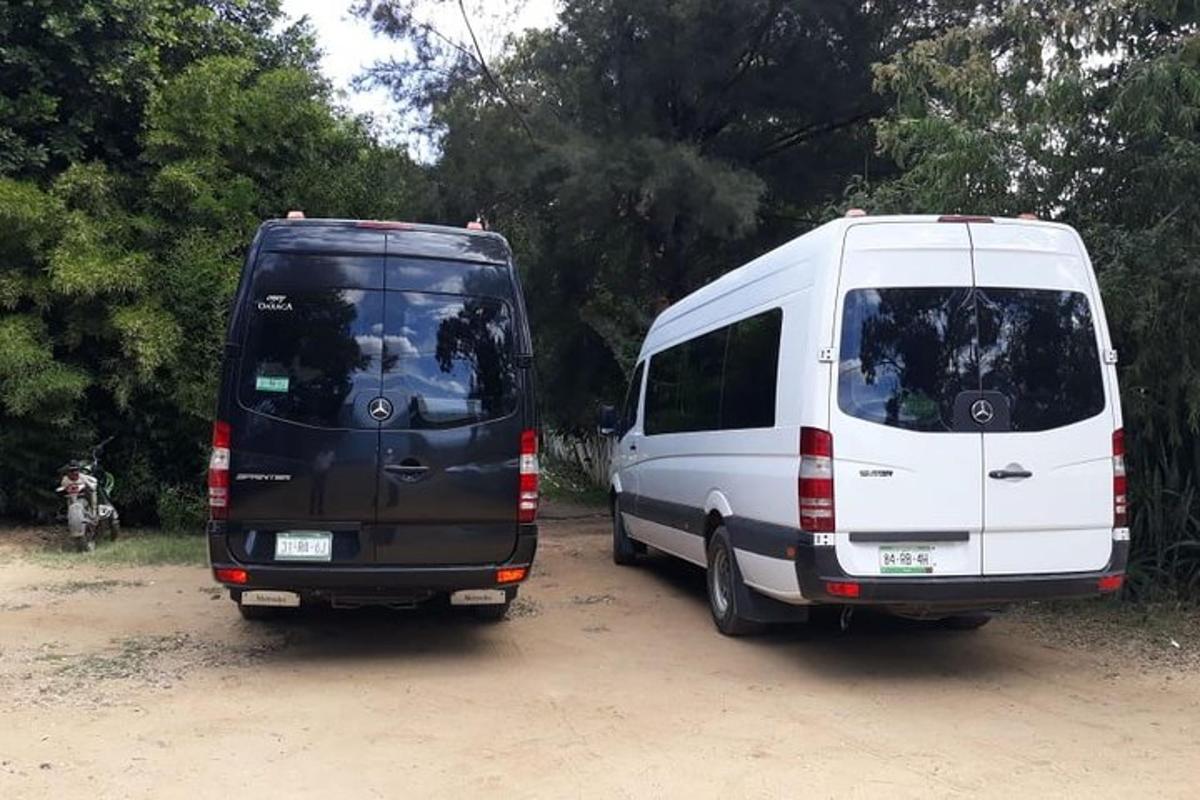 two vans parked next to each other on a dirt road