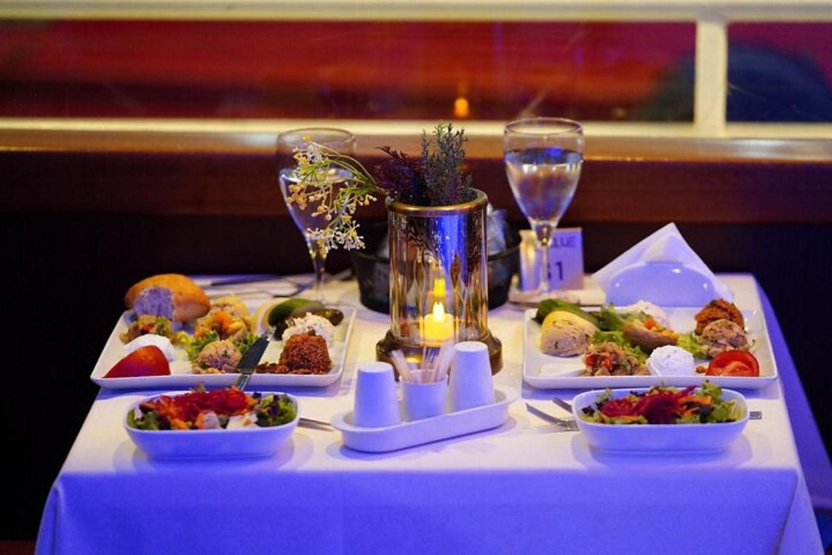 una mesa con platos de comida y copas de vino