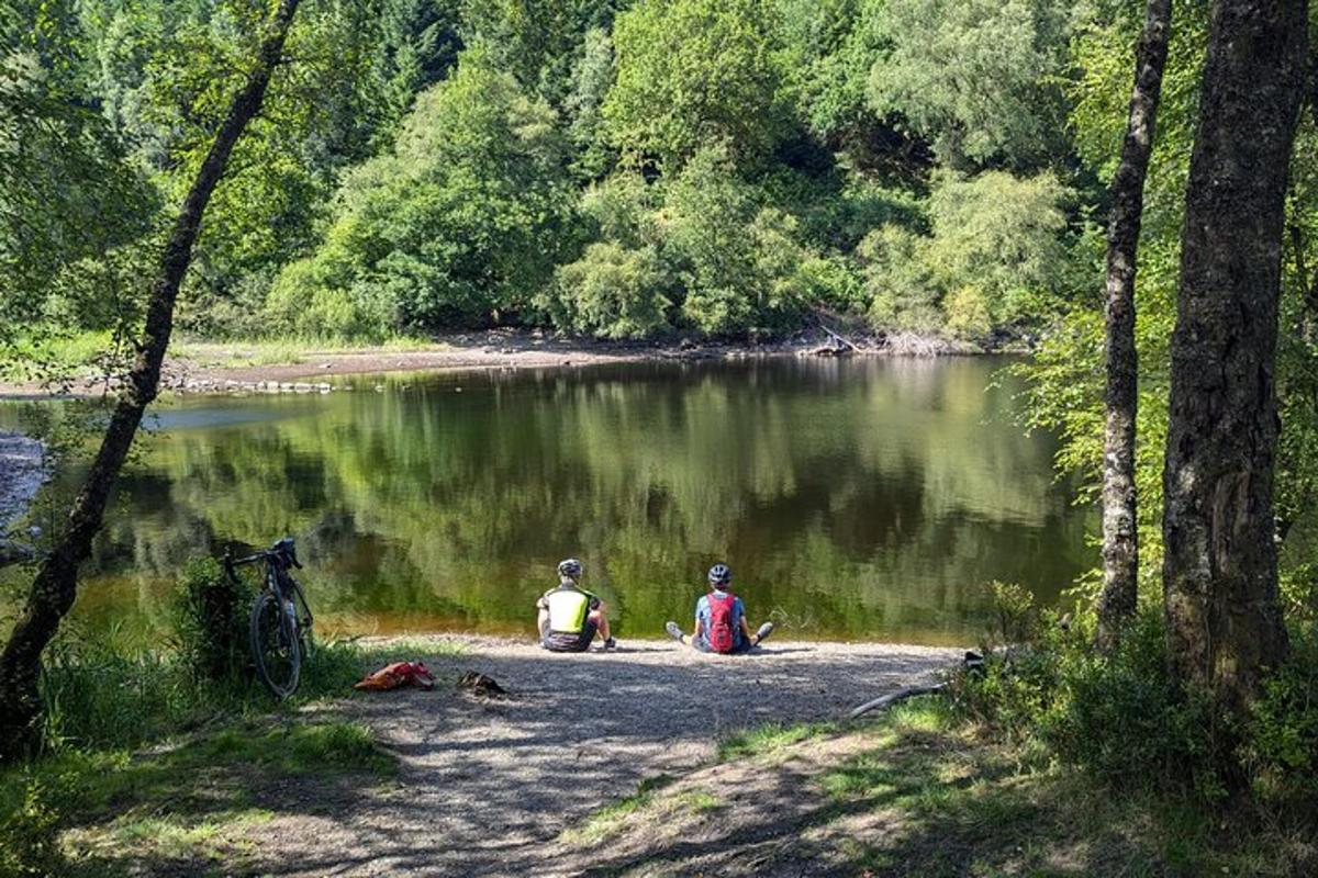 kaks inimest istuvad järve kaldal