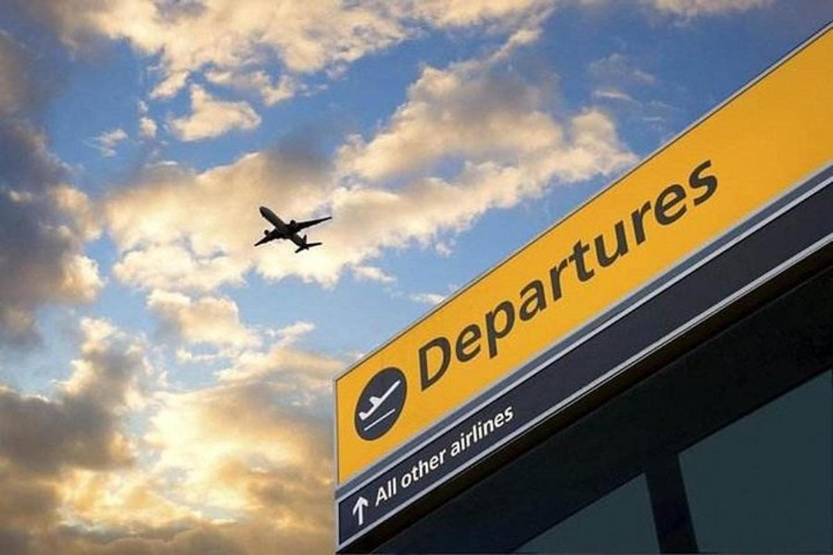 um avião está voando sobre uma placa com o céu