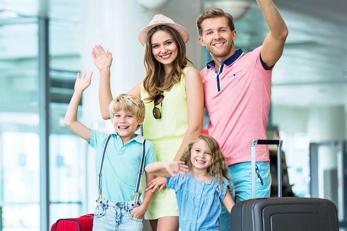 Una familia posando con su equipaje en un aeropuerto.