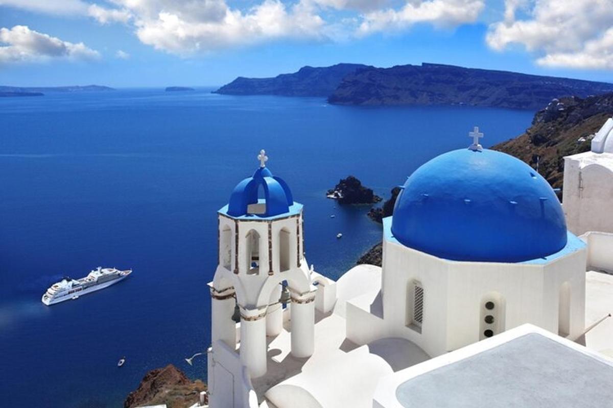 una iglesia con una cúpula azul sobre el océano