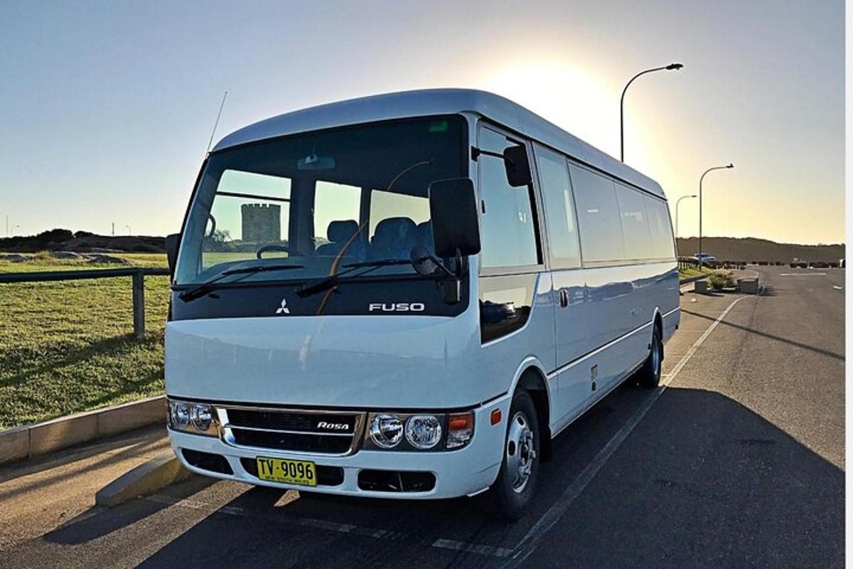 a white bus is parked in a parking lot