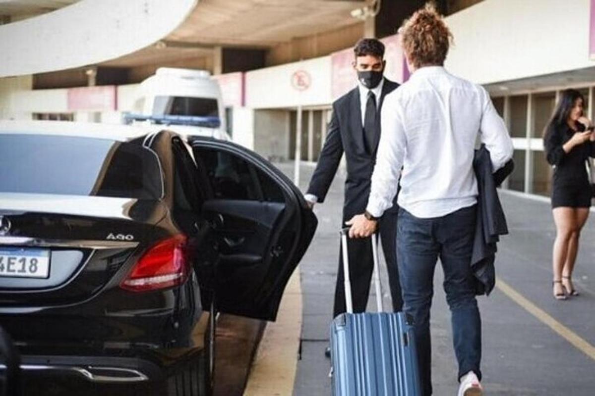 Δύο άντρες με μια βαλίτσα που βγαίνουν από ένα αυτοκίνητο