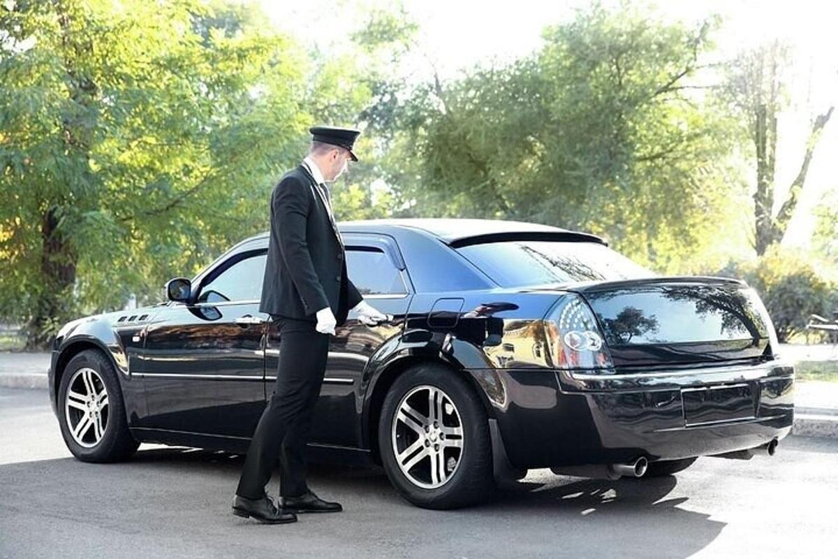 Un hombre parado junto a un coche negro