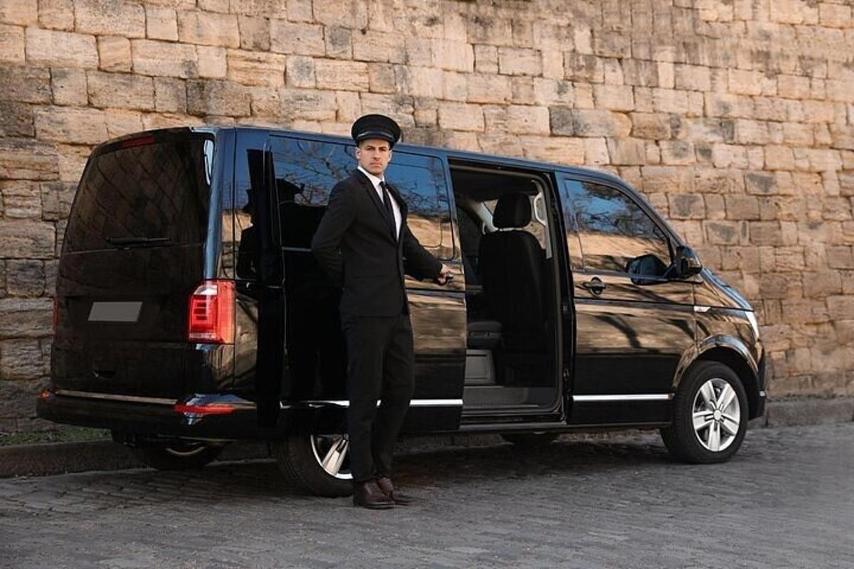 Un hombre con traje de pie junto a una camioneta.