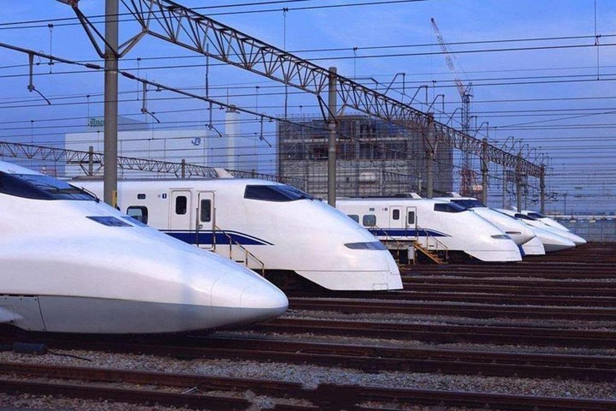 a row of white trains parked in a train station