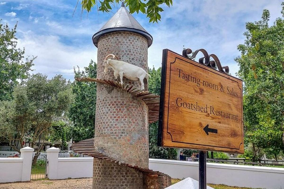 a statue of a goat on a tower with a sign