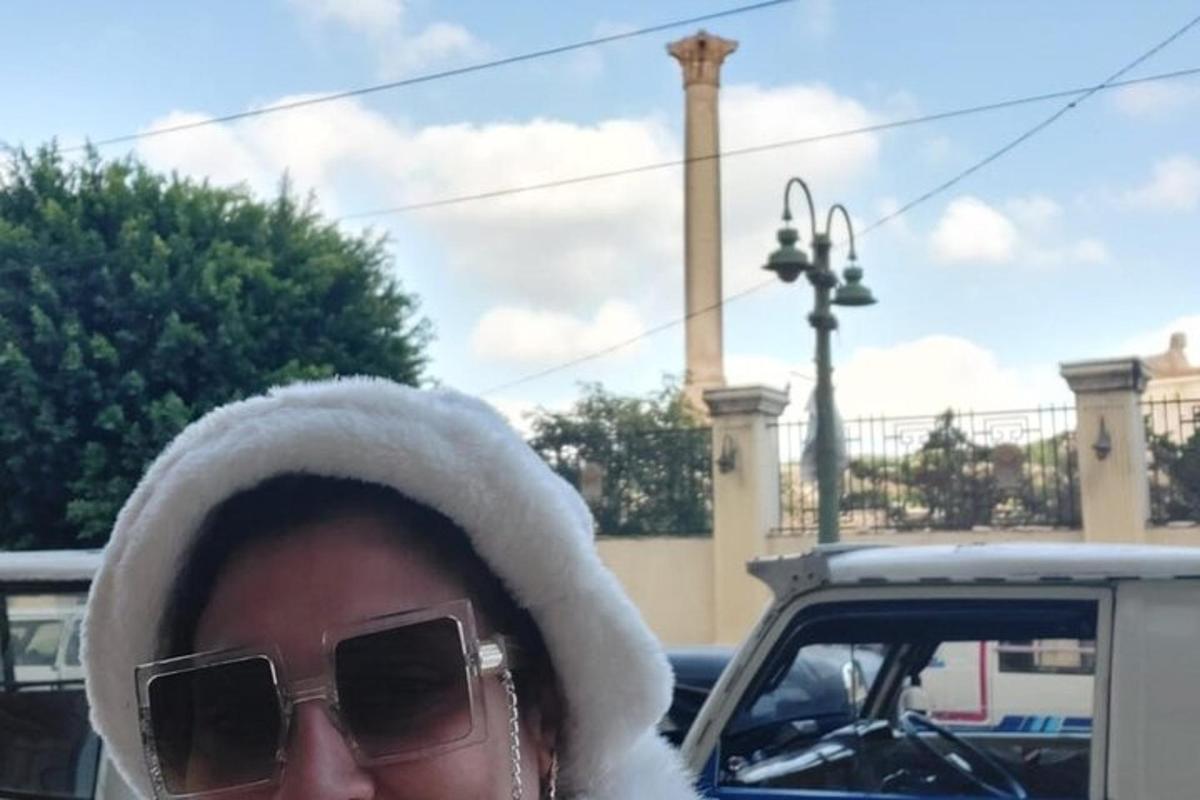 žena se slunečními brýlemi, kloboukem a auto
