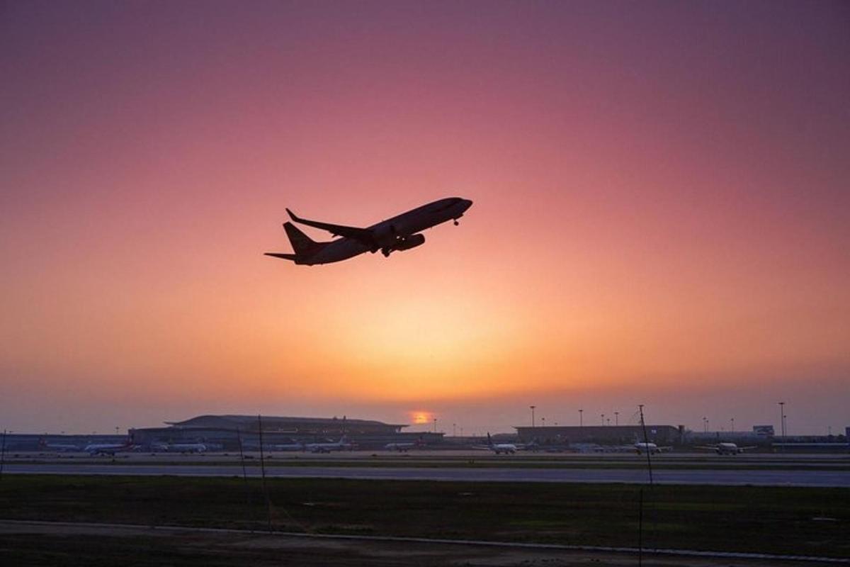 an airplane taking off from an airport runway at sunset