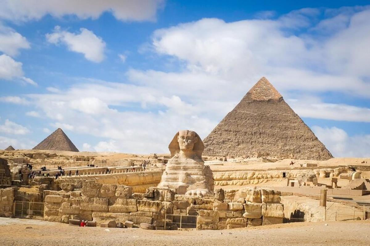 en løvestatue som sitter foran pyramidene