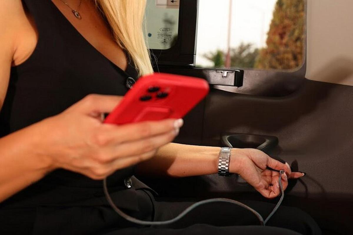 egy nő piros mobiltelefont tart a kezében