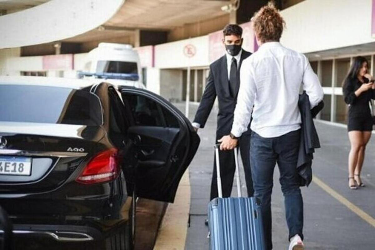 Δύο άντρες με μια βαλίτσα που βγαίνουν από ένα αυτοκίνητο