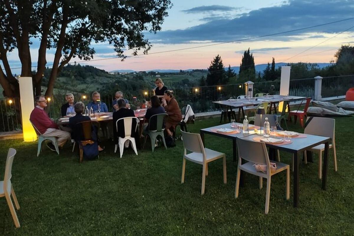 a group of people sitting at tables in the grass