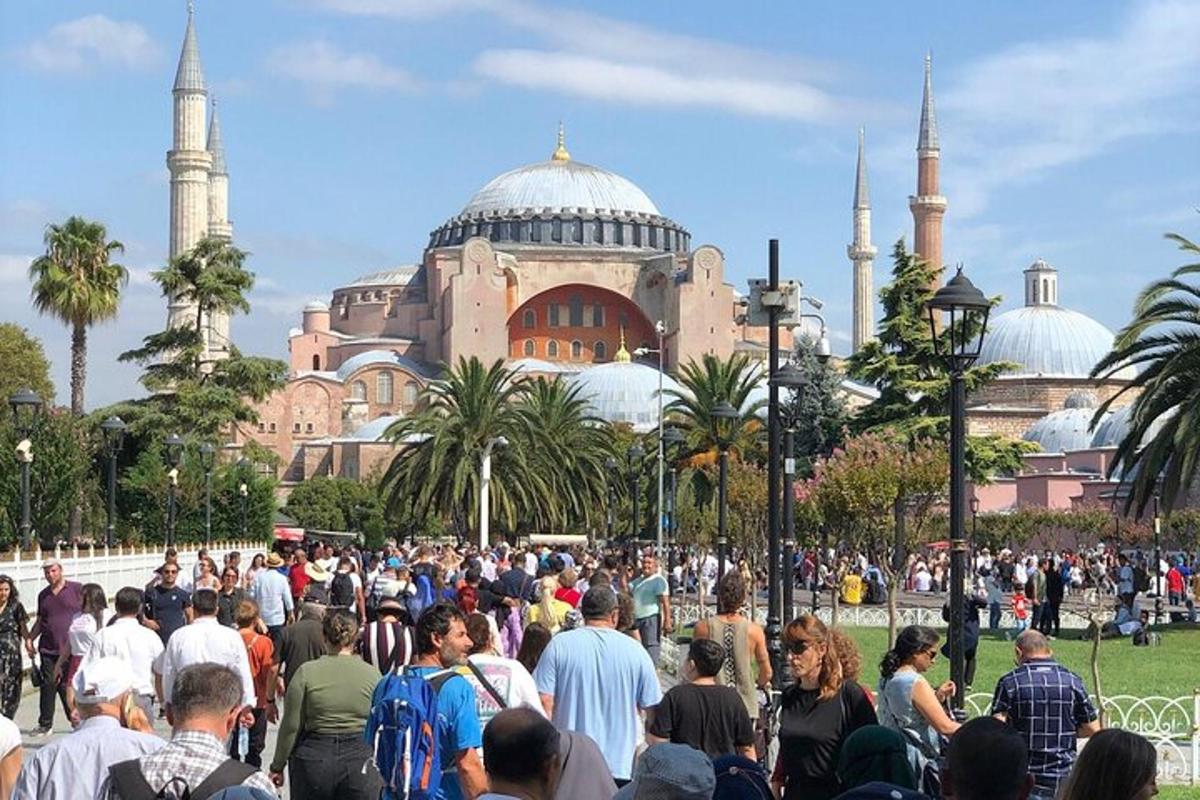 una multitud de personas caminando frente a una mezquita