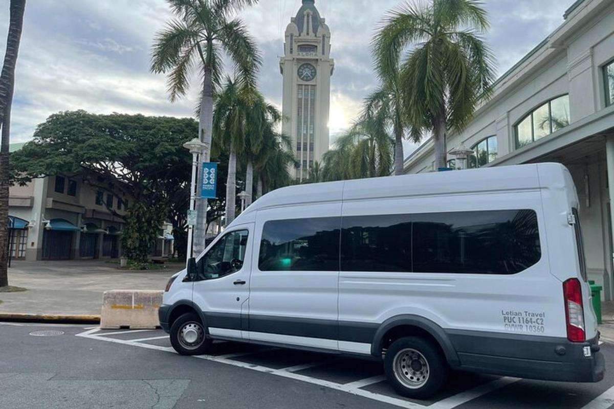 a white van parked in a parking lot with a clock tower