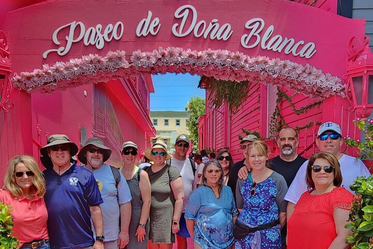 a group of people standing in front of a pink building