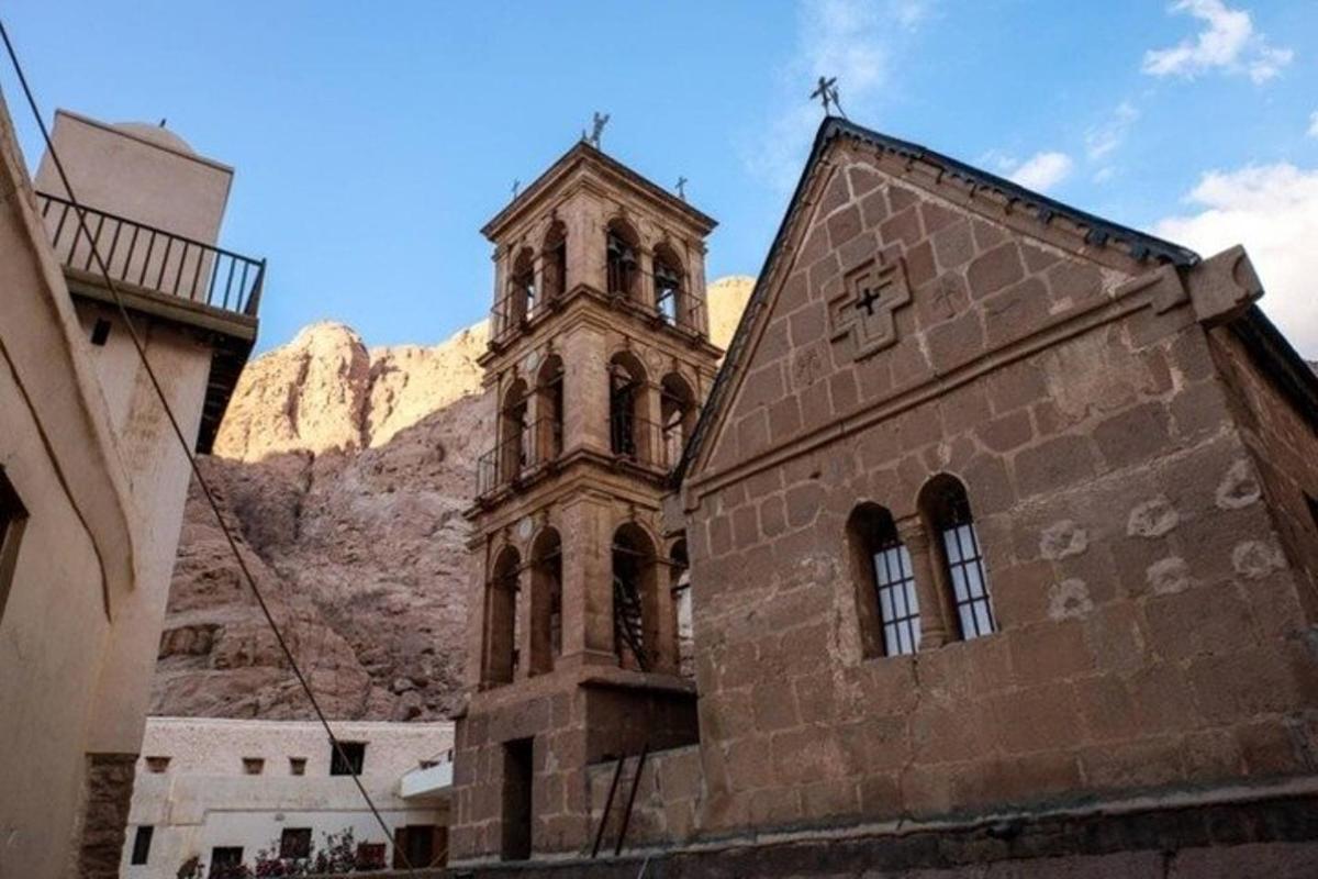 una chiesa con un campanile di fronte a una montagna