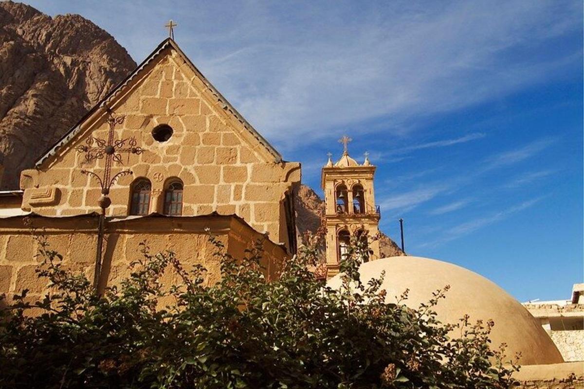 una chiesa con un campanile di fronte a una montagna