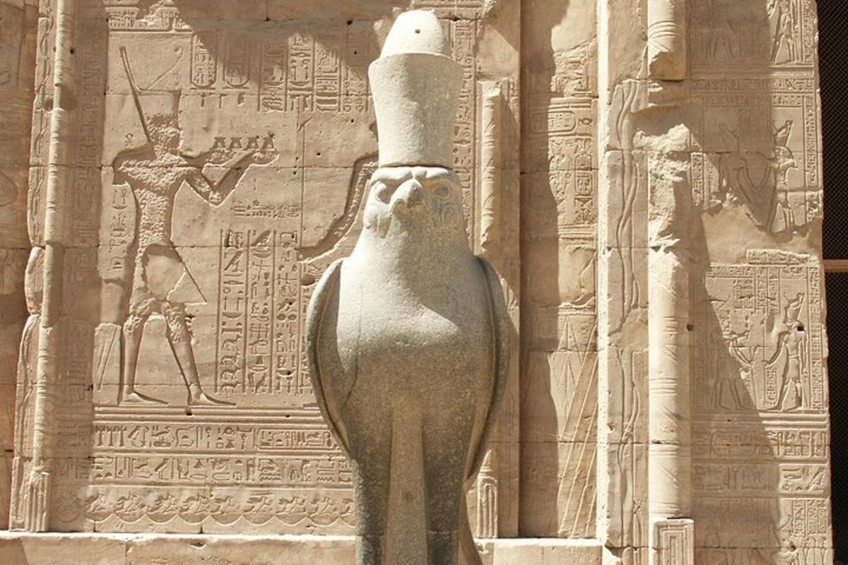 una statua di Anubi in piedi davanti a un muro