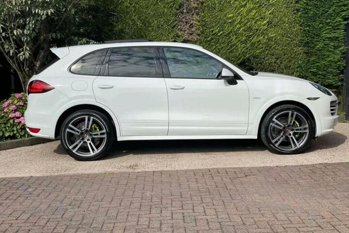 bílé auto zaparkované na cihlové silnici