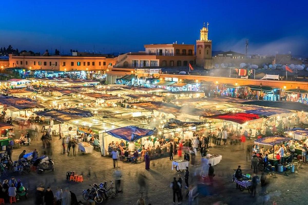 a crowd of people walking around a market at night