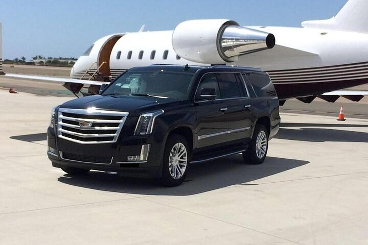 a black truck is parked next to an airplane