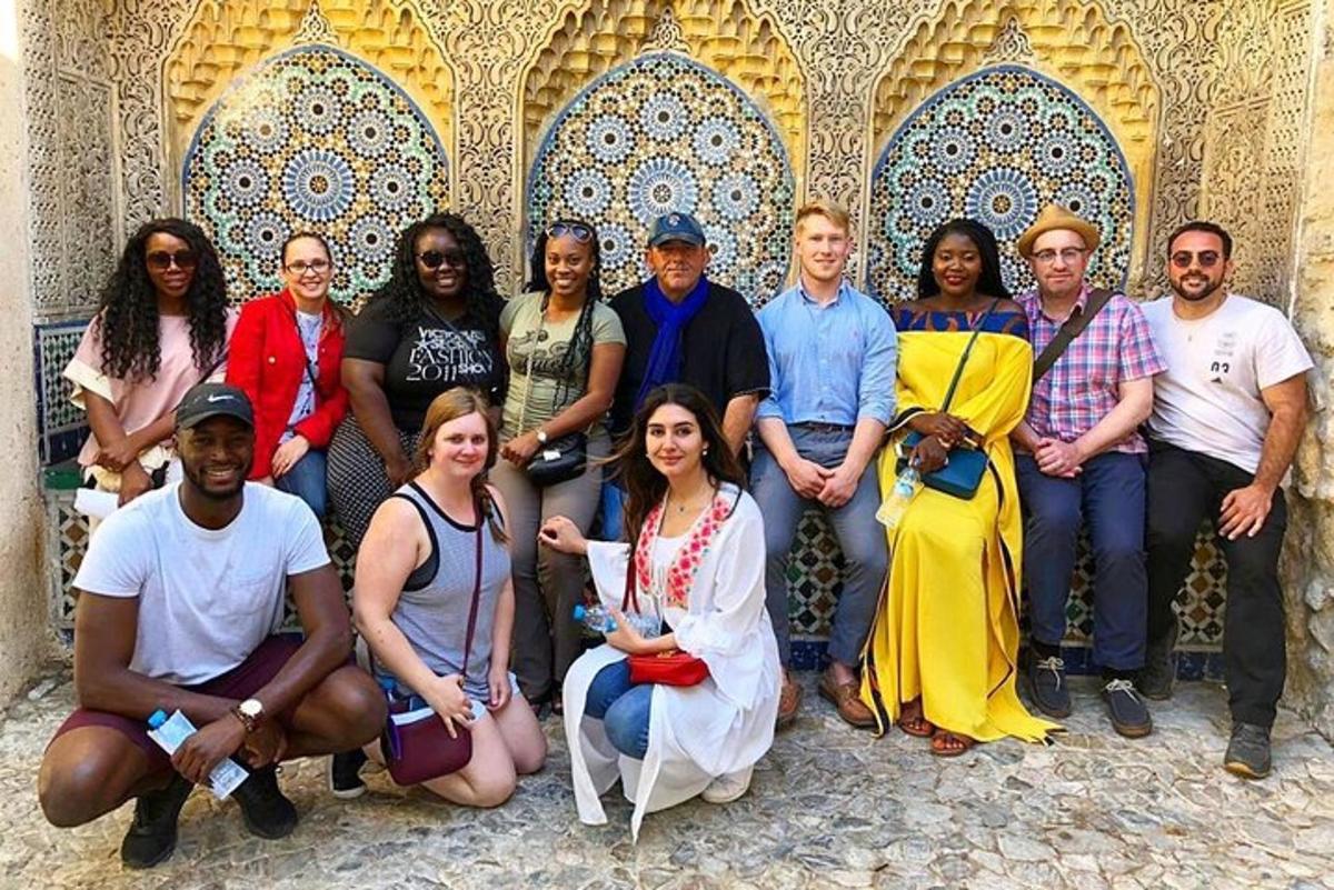 a group of people posing for a picture in front of a building