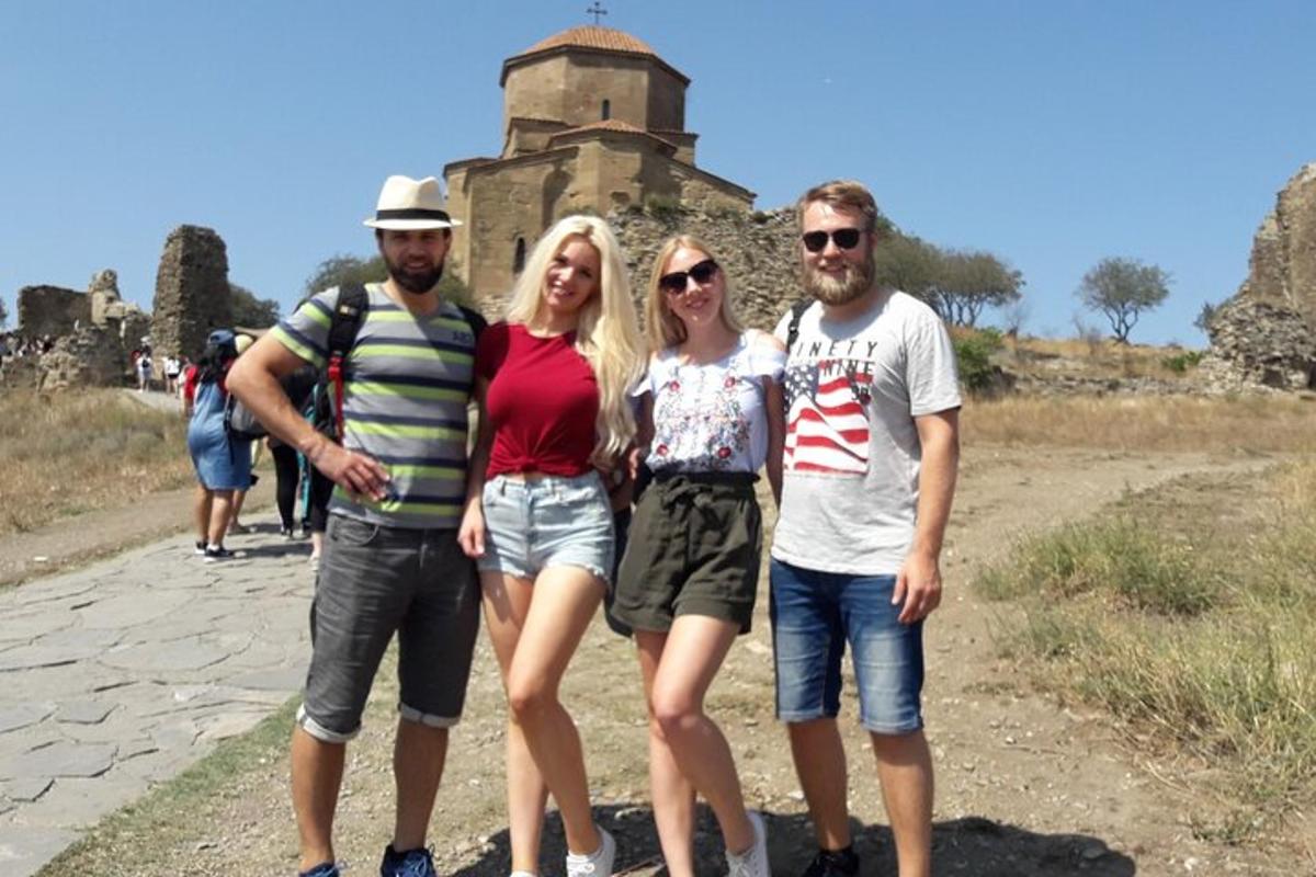 skupina lidí stojící před hradem