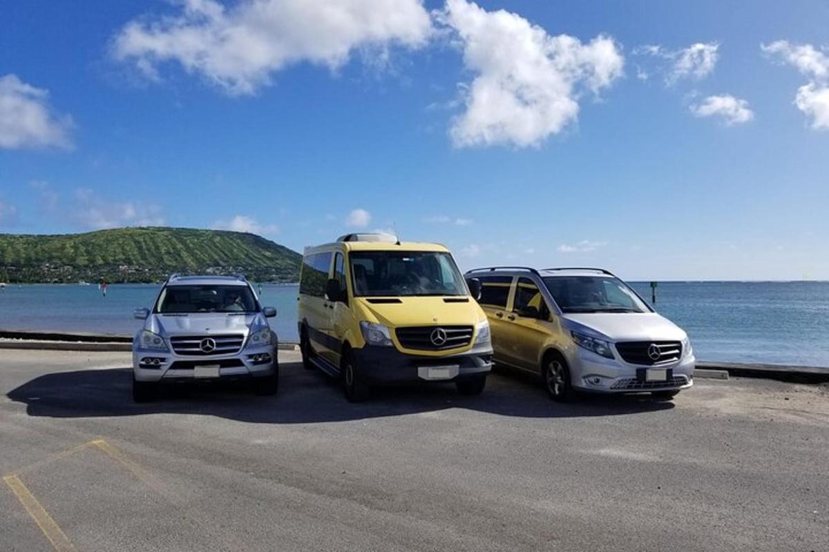 tri vozila parkirana na parkirišču ob oceanu