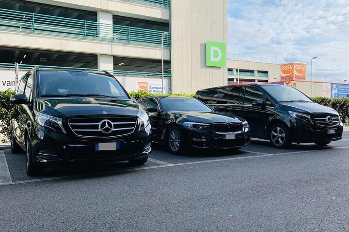 tři auta zaparkovaná na parkovišti před budovou