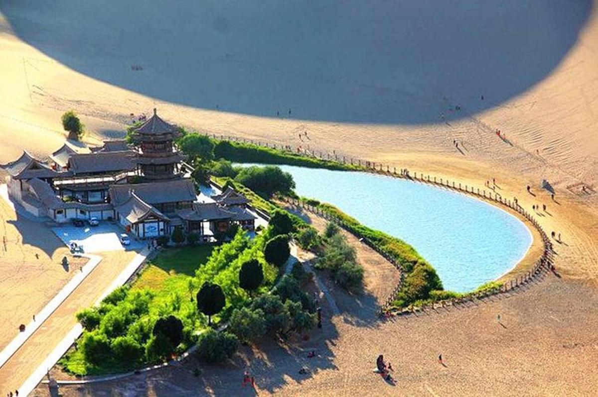 un edificio en el desierto junto a un cuerpo de agua
