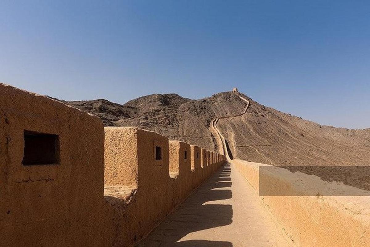 Un camino de tierra en el desierto con una montaña al fondo