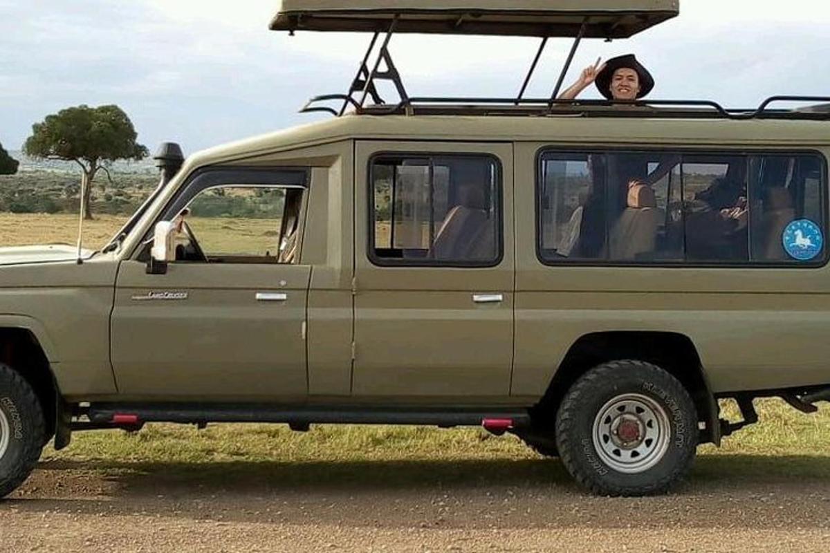 un bărbat stând în spatele unui jeep verde