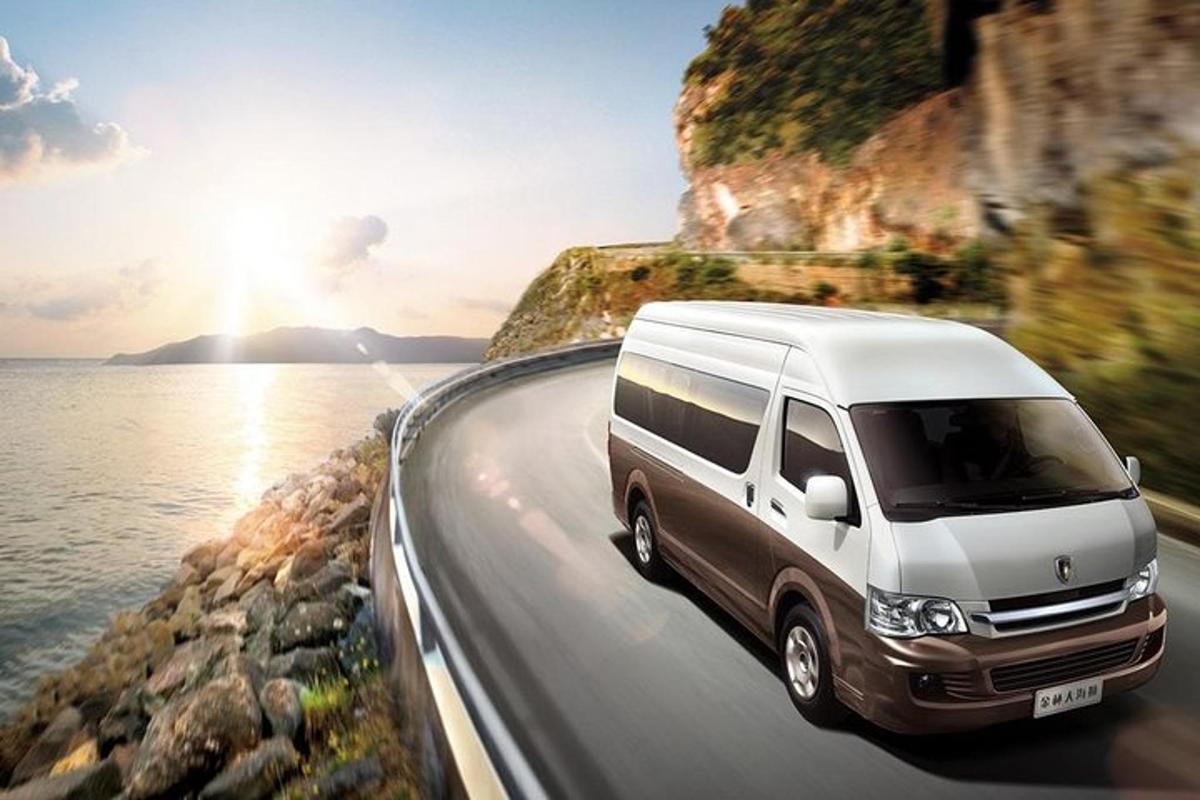 a white van driving down a road near the ocean