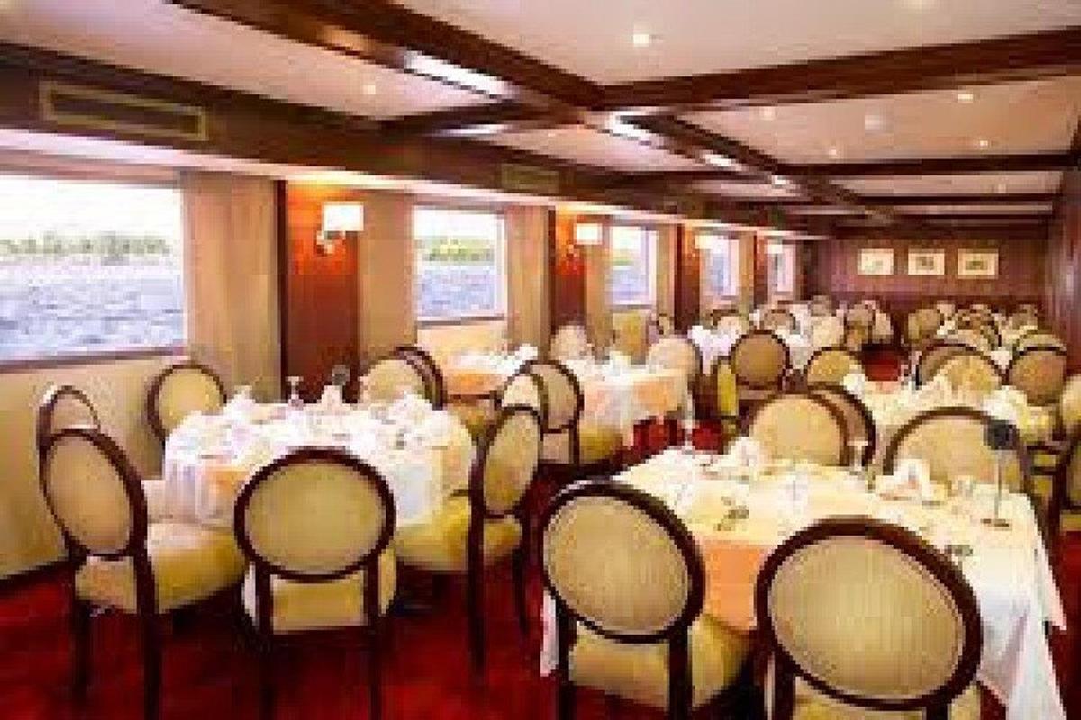 Una sala de conferencias con mesas y sillas con mantel blanco.