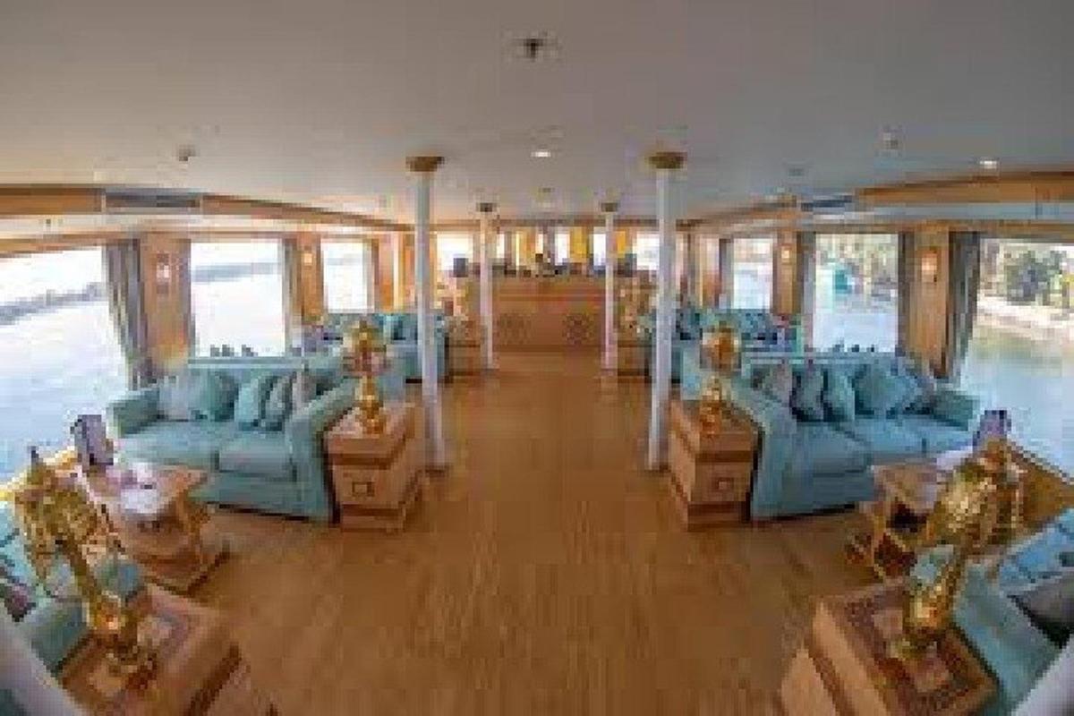 Una habitación con sofás y mesas azules y ventanas.