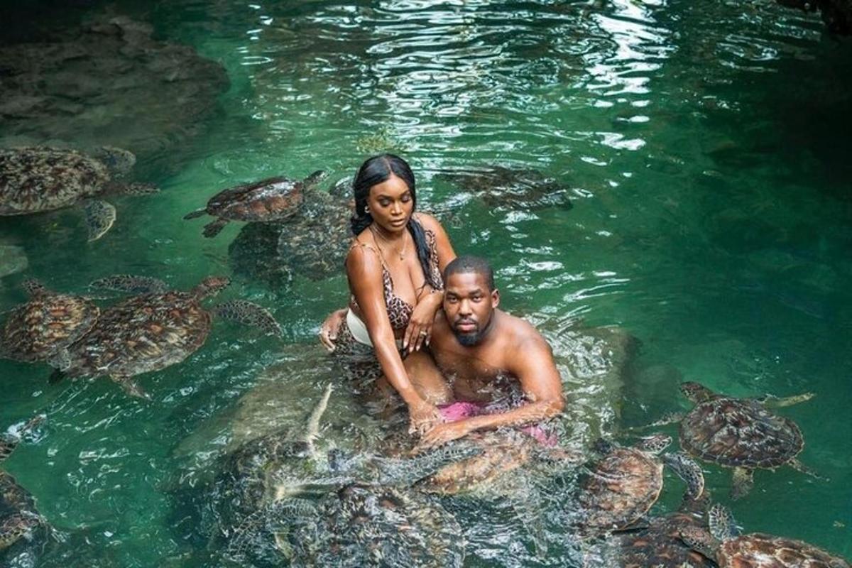 un uomo e una donna in acqua con le tartarughe