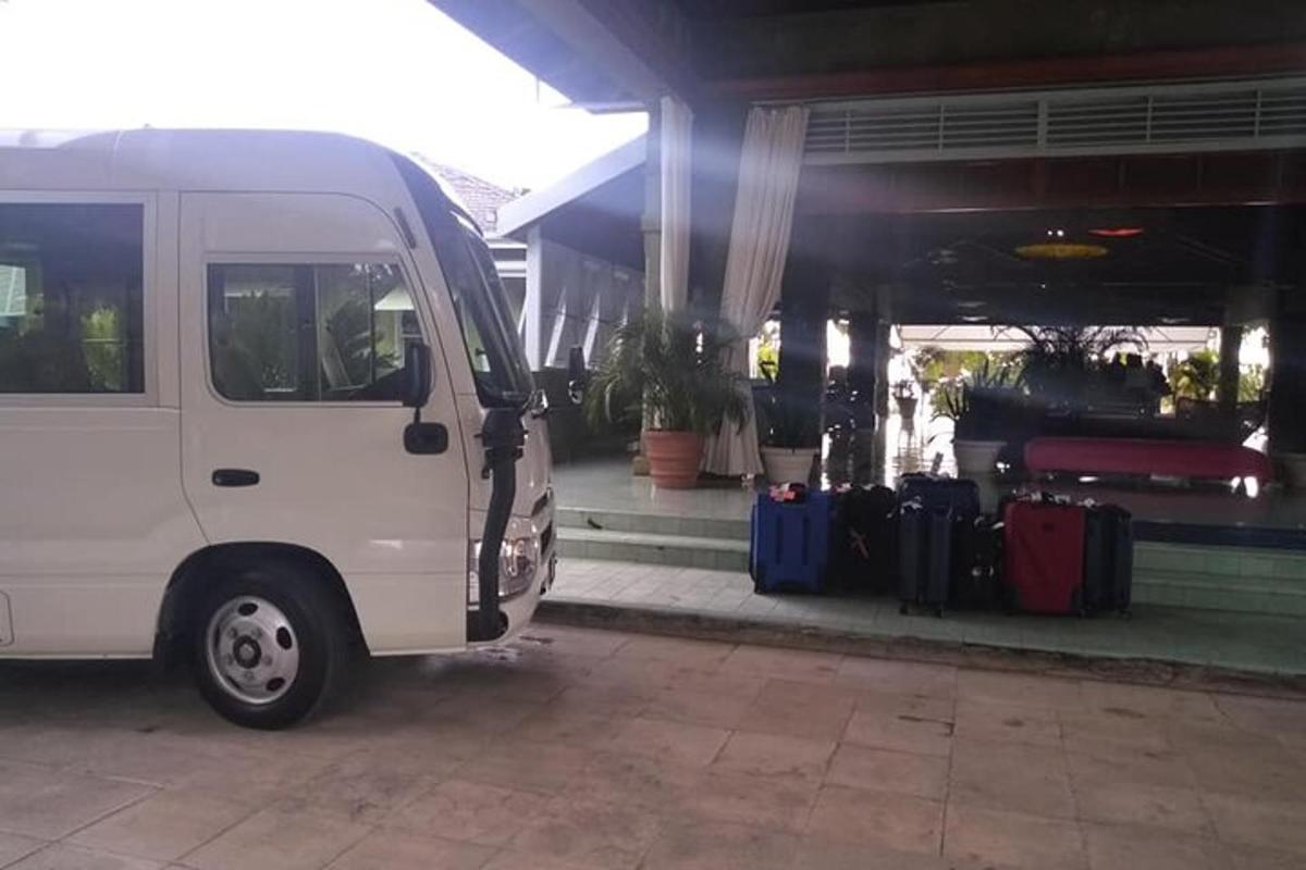 một chiếc xe tải màu trắng đậu trước một tòa nhà có hành lý