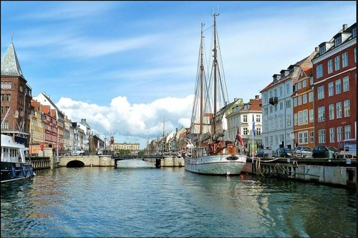 Bátur liggur við bryggju í á í borg