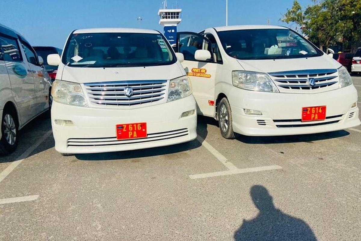 Dos furgonetas blancas estacionadas una al lado de la otra en un estacionamiento