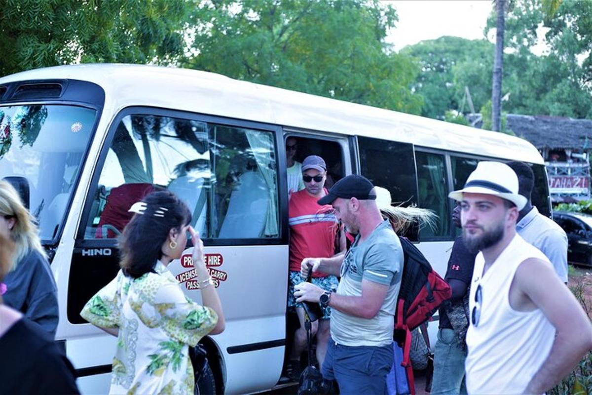 um grupo de pessoas em pé do lado de fora de um ônibus