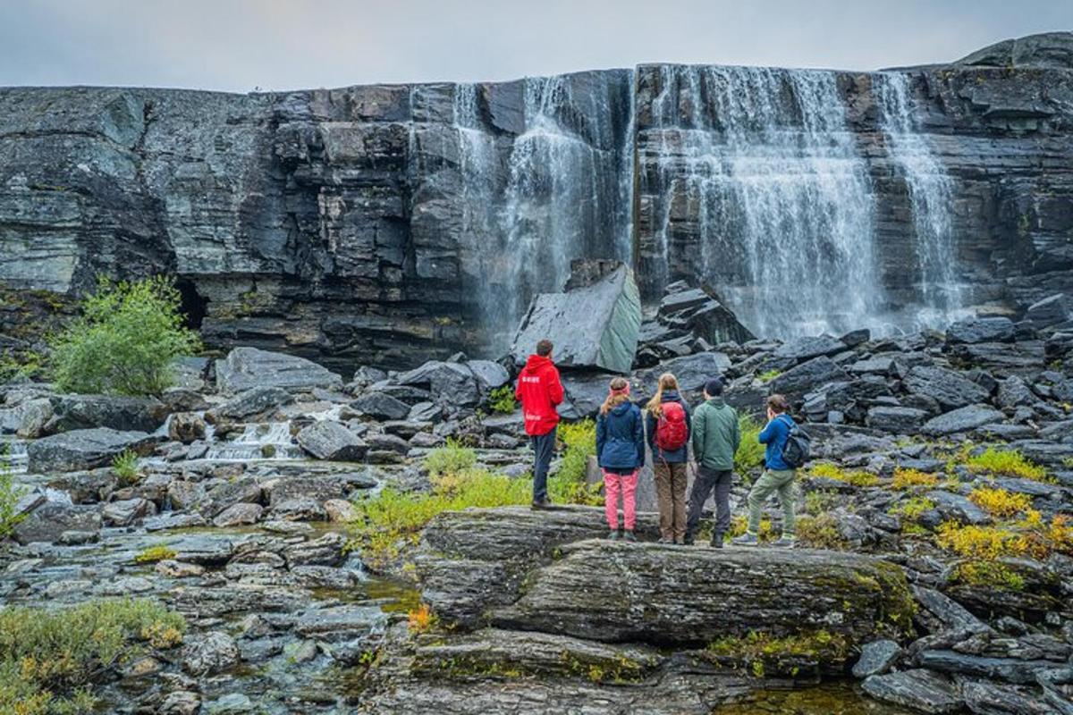 a group of people standing in front of a waterfall