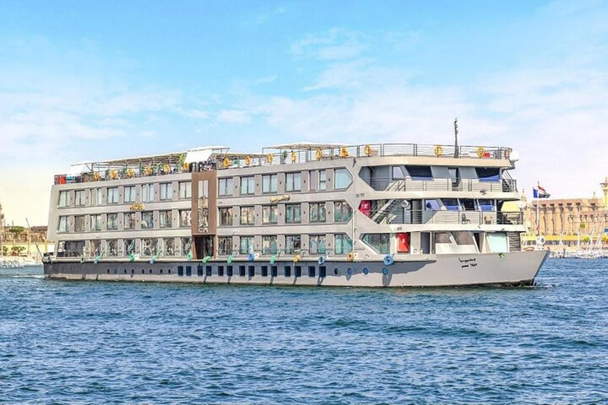 et stort cruiseskip i vannet ved siden av en bygning