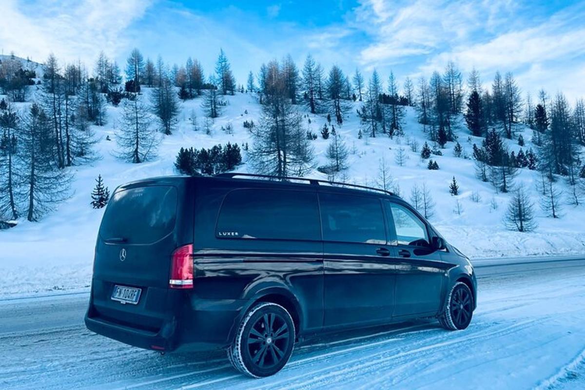 un SUV blu che percorre una strada innevata