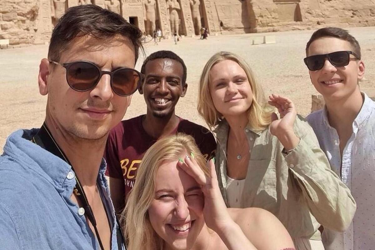 skupina lidí pózujících pro fotografii před pyramidou