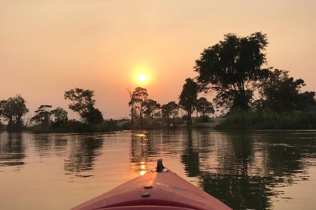 isang kayak sa isang ilog na lumulubog ang araw